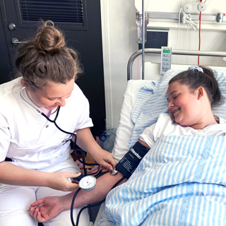 Foto af sygeplejerske, der måler blodtryk på patient