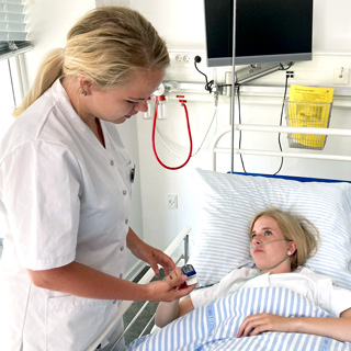 Foto af sygeplejerske, der taler med patient